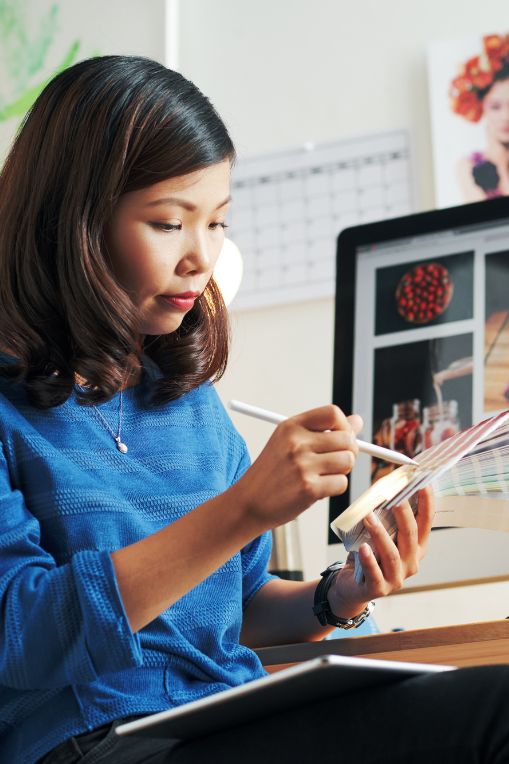 Designer working with colour palettes and digital images on a computer screen, showcasing creative content development supported by an Answer Engine.