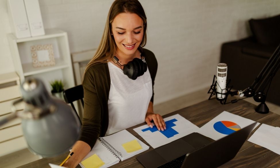 A marketing professional analysing digital charts and campaign data at her desk, representing paid strategies and hybrid marketing in 2026.