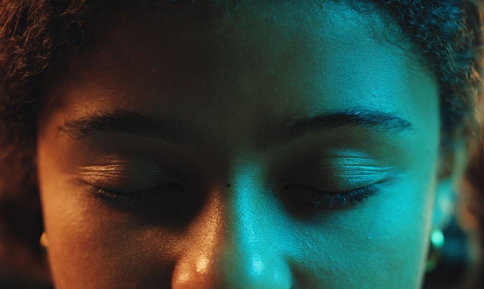 Close-up of a person with eyes closed under soft lighting, symbolising emotion, empathy and a human-first marketing approach.