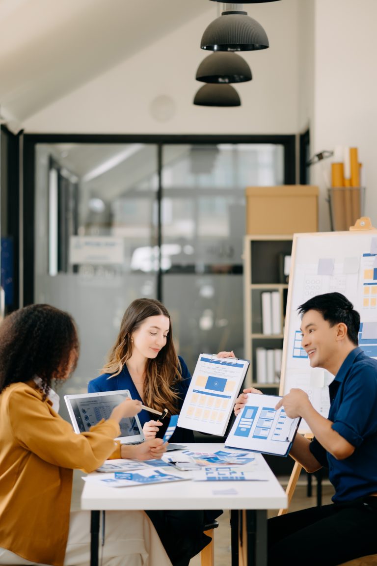 Marketing agency team collaborating on branding, website design, and ChatGPT ads strategy while reviewing marketing campaign layouts and digital design concepts in a modern office.